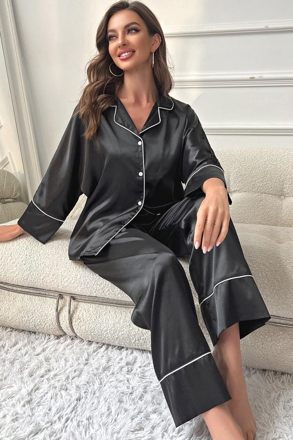 Black satin button-up pajama top with contrast piping and matching wide-leg pants