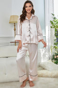 White satin button-up pajama top with contrast piping and matching wide-leg pants