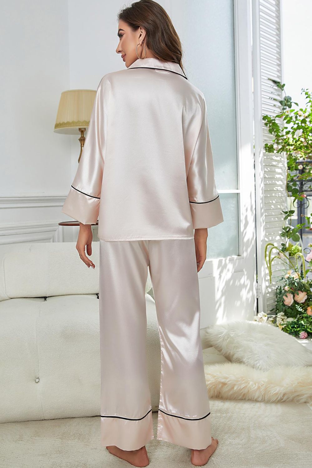 White satin button-up pajama top with contrast piping and matching wide-leg pants