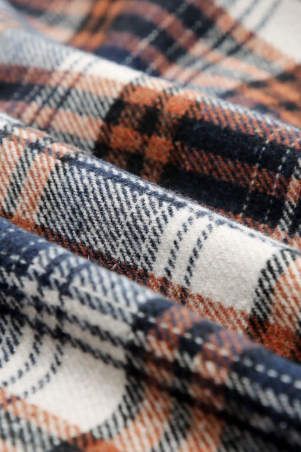 Multicolor plaid button-up shacket with sherpa-lined hood, worn open over a cream sweater