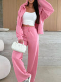 Dusty pink zip-up hoodie and drawstring wide-leg loungewear set, worn with hand raised to hair