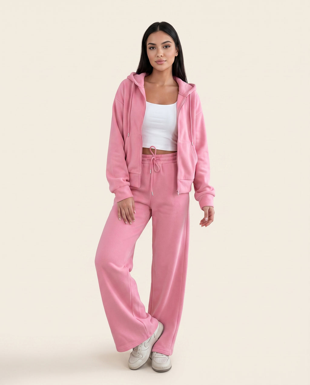 Dusty pink zip-up hoodie and drawstring wide-leg loungewear set, worn with hand raised to hair