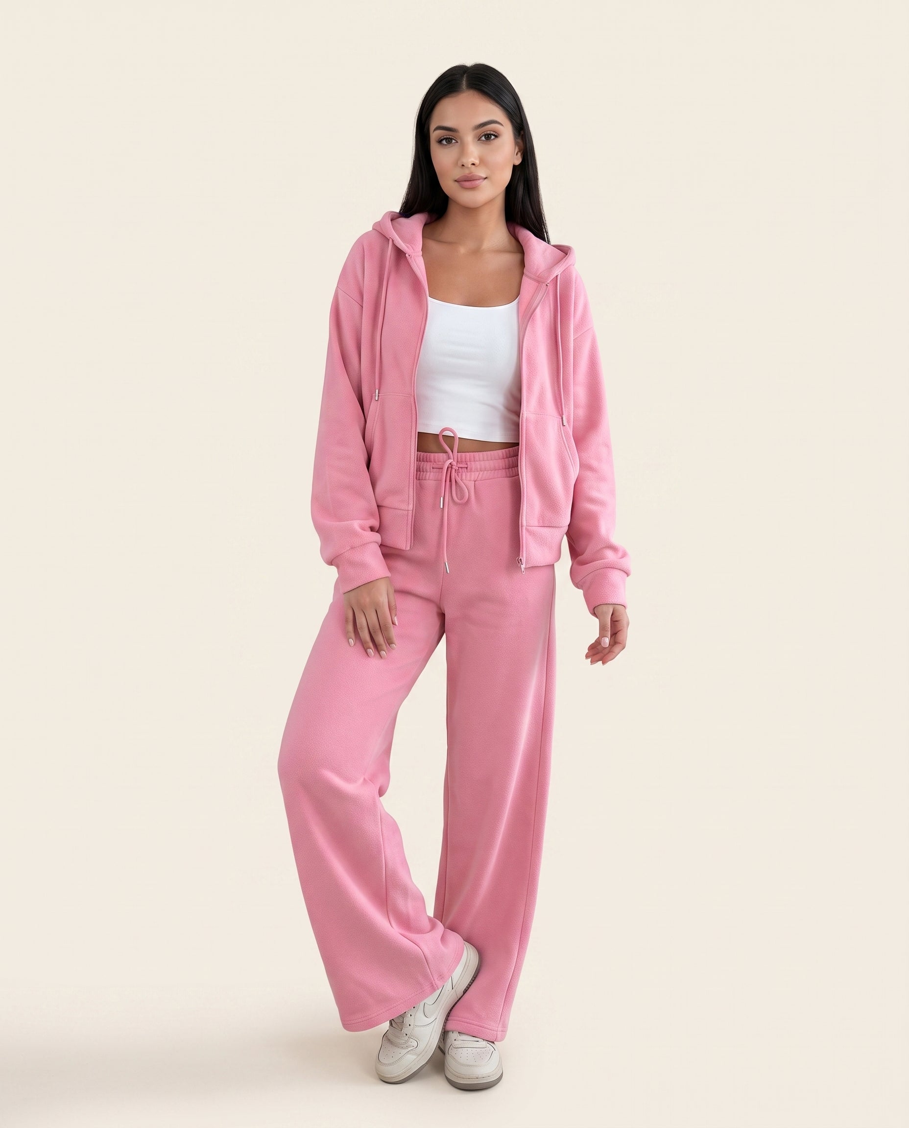 Dusty pink zip-up hoodie and drawstring wide-leg loungewear set, worn with hand raised to hair