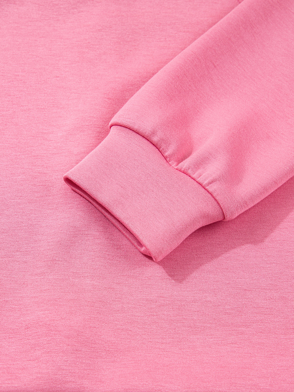 Dusty pink zip-up hoodie and drawstring wide-leg loungewear set, worn with hand raised to hair