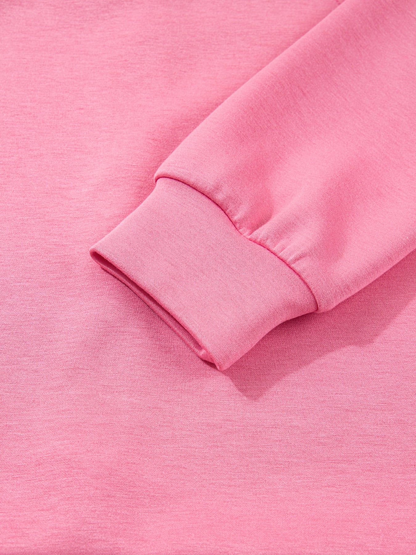 Dusty pink zip-up hoodie and drawstring wide-leg loungewear set, worn with hand raised to hair