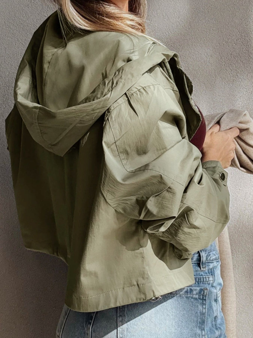 Yellow-green cropped utility jacket with hood, worn open over a tank top