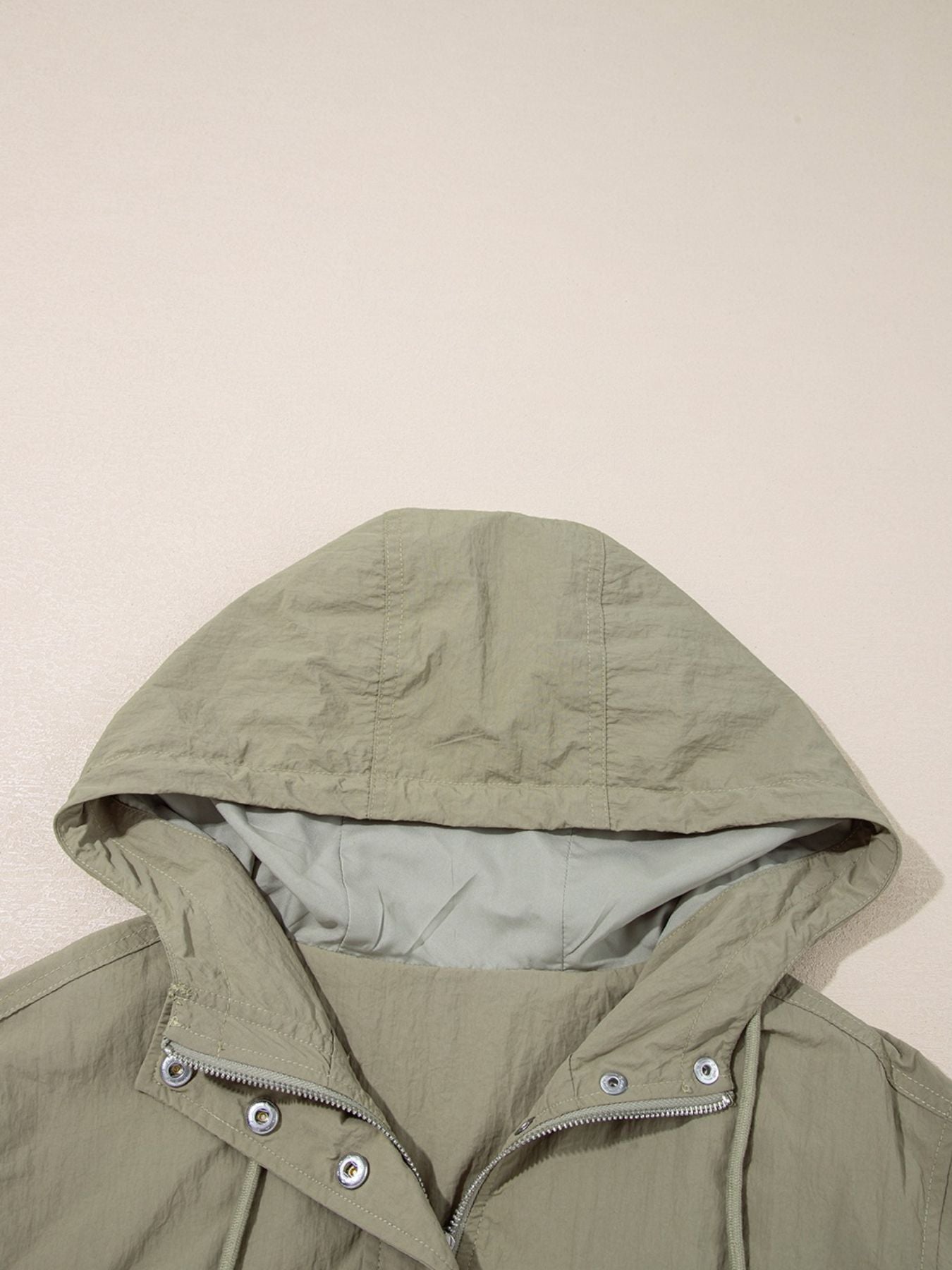 Yellow-green cropped utility jacket with hood, worn open over a tank top