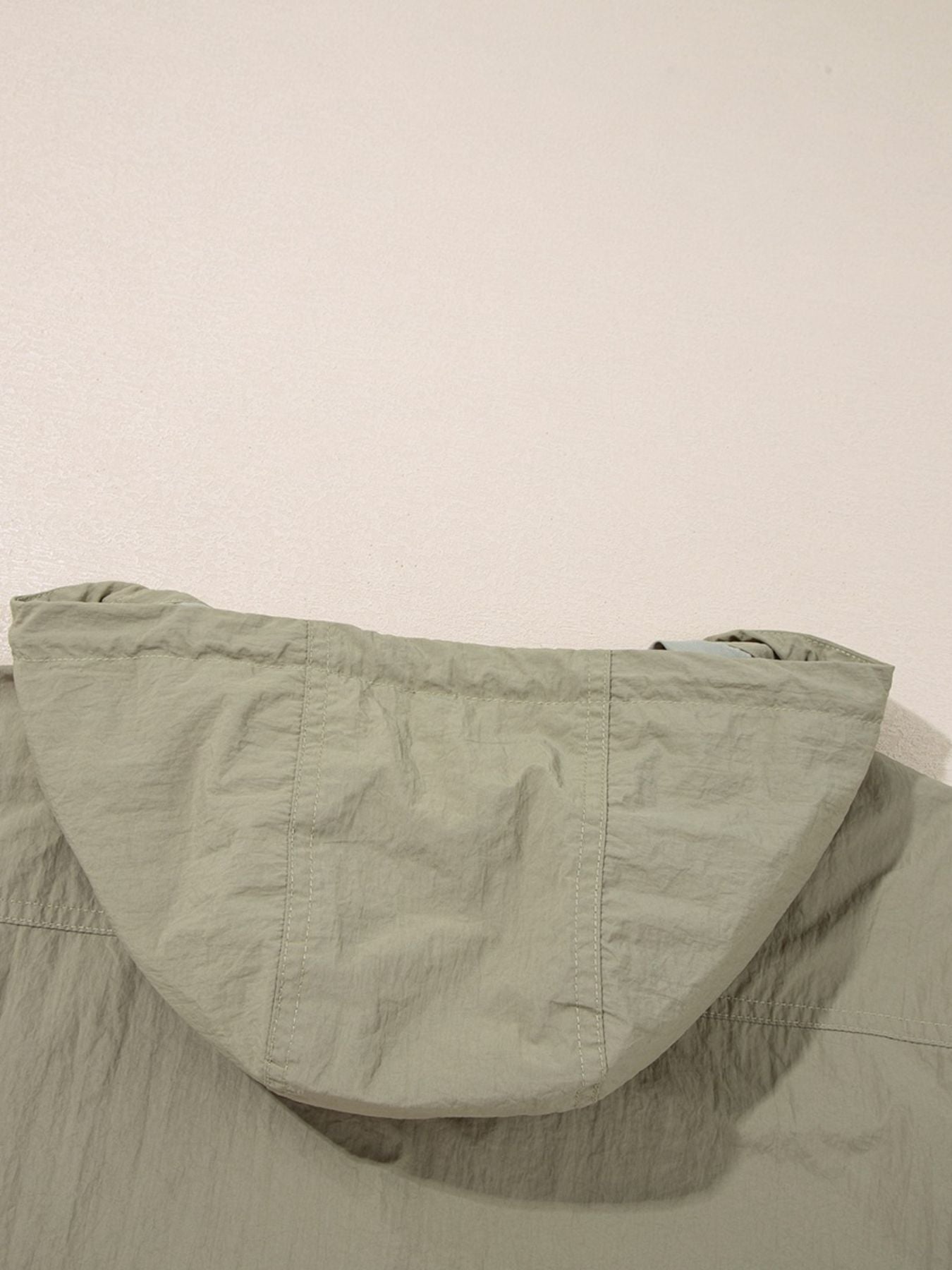 Yellow-green cropped utility jacket with hood, worn open over a tank top