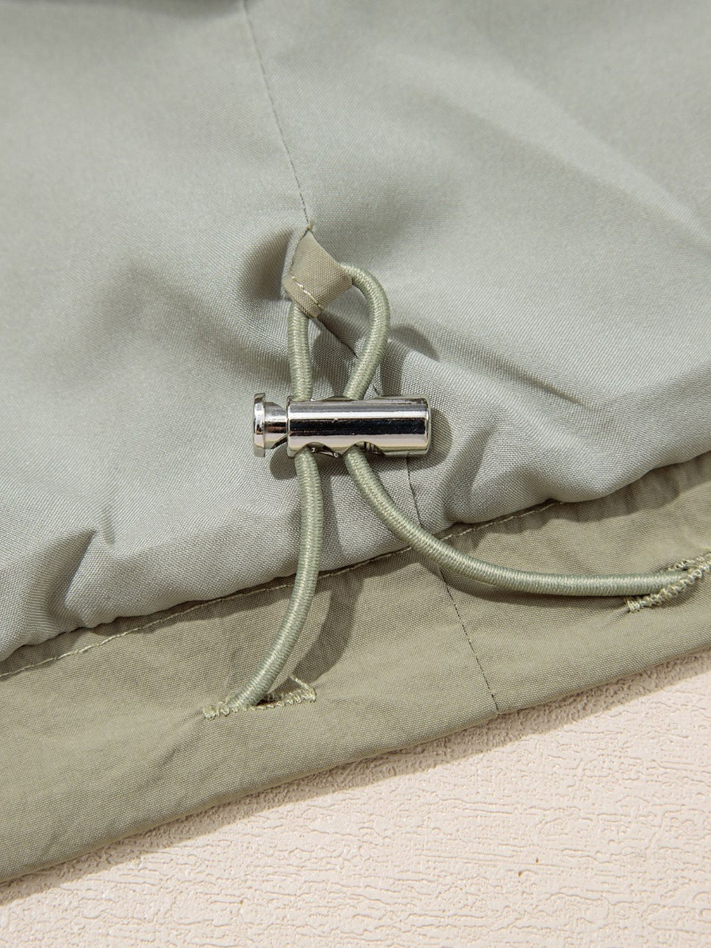 Yellow-green cropped utility jacket with hood, worn open over a tank top