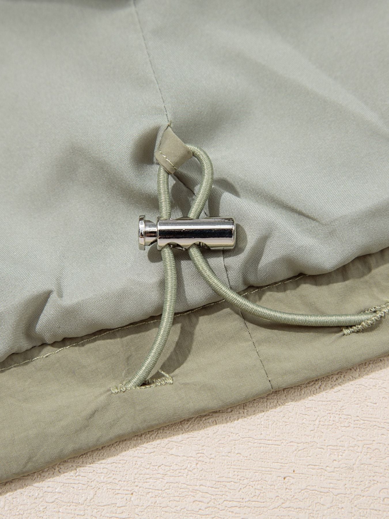 Yellow-green cropped utility jacket with hood, worn open over a tank top
